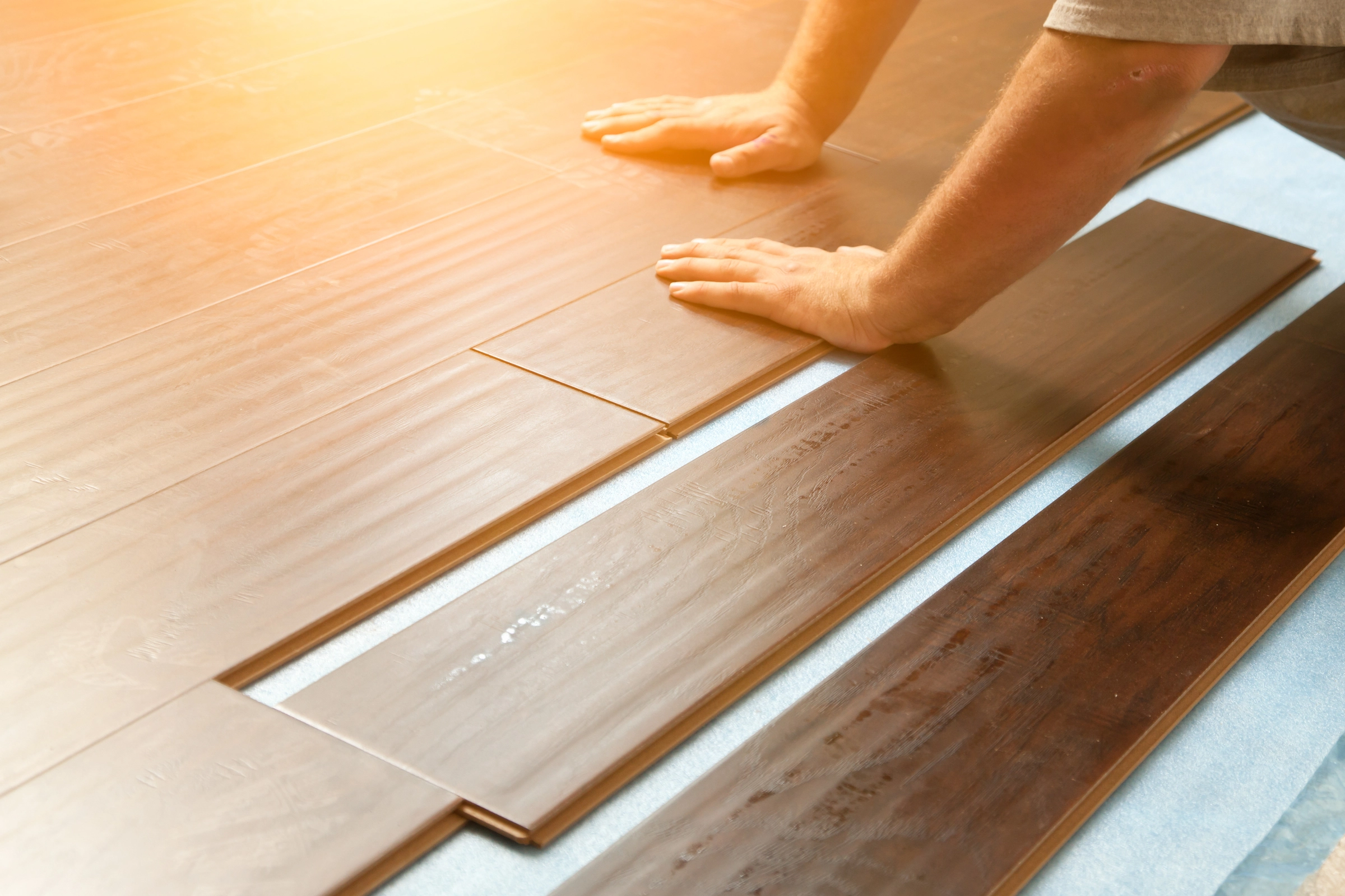 large-man-installing-new-laminate-wood-flooring